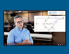 man lecturing next to board with circuit diagram