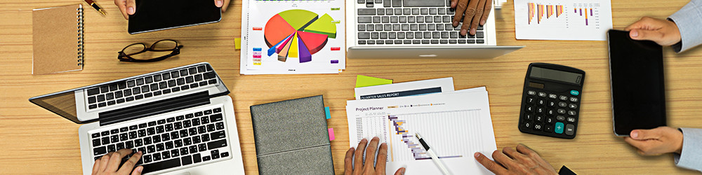 Conference table with hands working on electronic devices